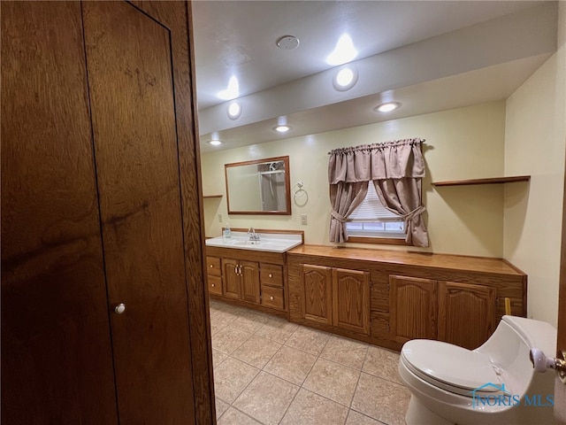 bathroom featuring tile patterned flooring, vanity, and toilet