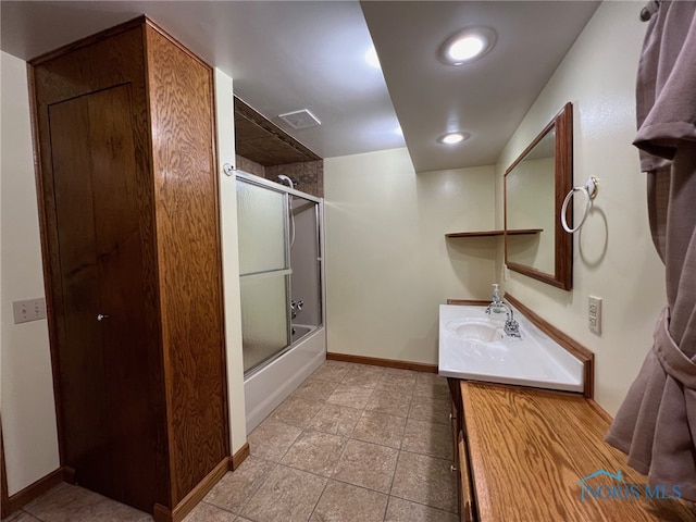 bathroom featuring shower / bath combination with glass door and vanity