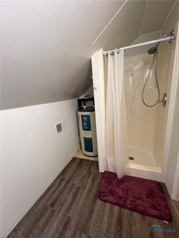 bathroom featuring curtained shower, electric water heater, wood-type flooring, and lofted ceiling