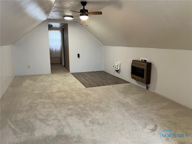 additional living space with carpet flooring, ceiling fan, vaulted ceiling, and heating unit