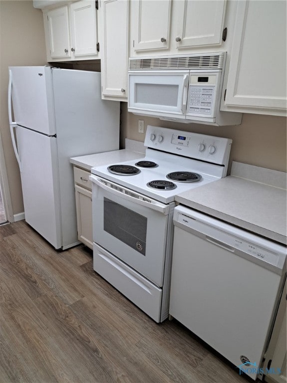 kitchen with white cabinets, wood-type flooring, and white appliances