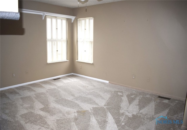 unfurnished room featuring ceiling fan and carpet