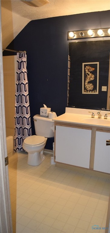 full bathroom featuring shower / tub combo, vanity, toilet, and vaulted ceiling