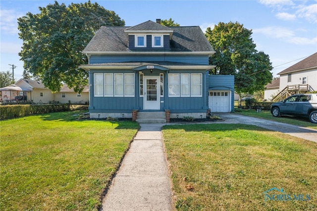 bungalow featuring a front yard and a garage