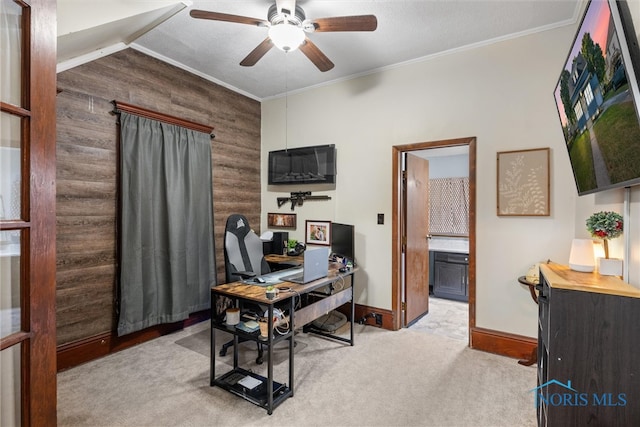 carpeted office space featuring ceiling fan, ornamental molding, and wood walls