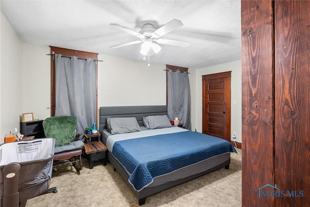 carpeted bedroom featuring a textured ceiling and ceiling fan