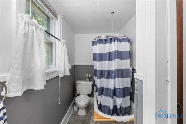 bathroom featuring curtained shower and toilet