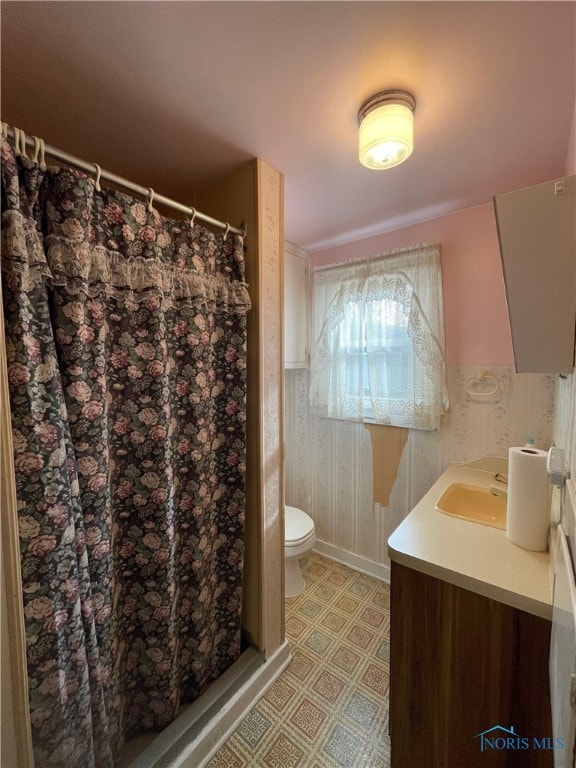 bathroom featuring walk in shower, vanity, and toilet