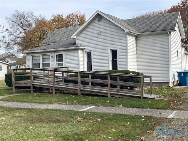 rear view of property with a lawn and a deck