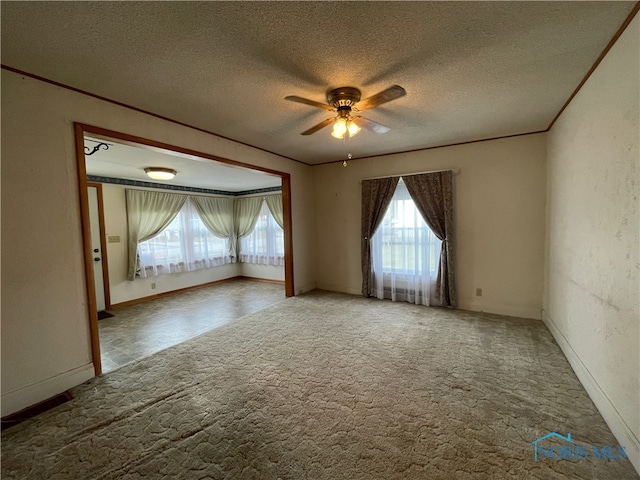 carpeted spare room with a textured ceiling and ceiling fan