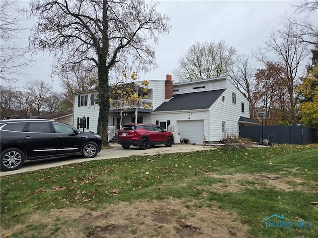 back of property with a garage and a lawn