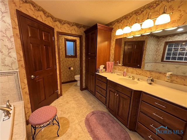 bathroom featuring tile patterned floors, vanity, toilet, and a textured ceiling