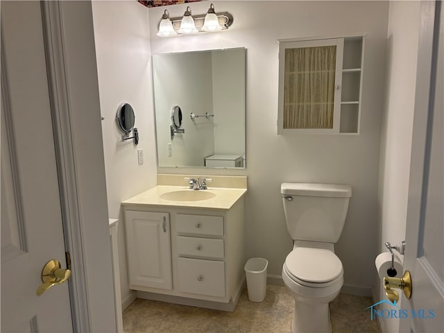 bathroom with tile patterned flooring, vanity, and toilet