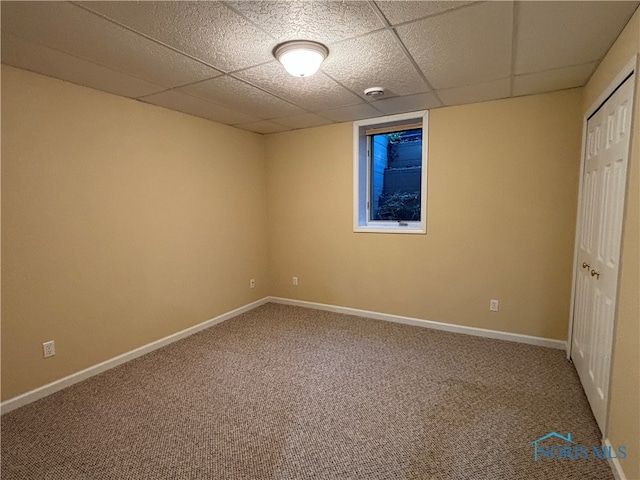 unfurnished room with carpet flooring and a paneled ceiling