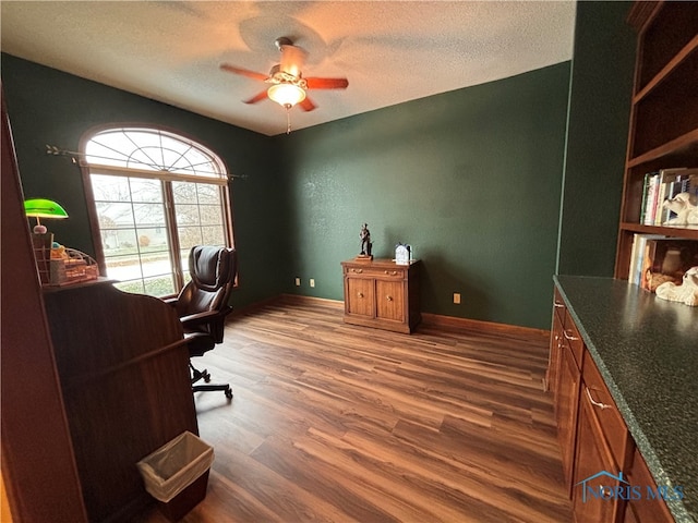 office space with a textured ceiling, ceiling fan, and dark wood-type flooring