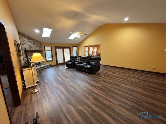 living room with dark hardwood / wood-style floors, lofted ceiling with skylight, and ceiling fan