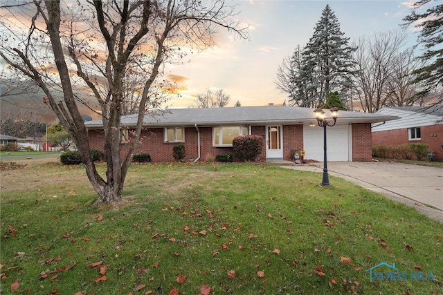 single story home featuring a garage and a lawn