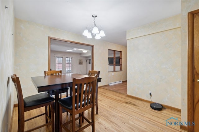 dining room with hardwood / wood-style flooring, an inviting chandelier, french doors, and a baseboard heating unit