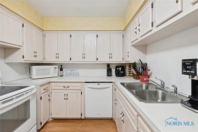 kitchen with light hardwood / wood-style flooring, white cabinets, white appliances, and sink