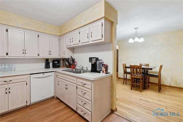 kitchen with dishwasher, an inviting chandelier, sink, hanging light fixtures, and light hardwood / wood-style floors