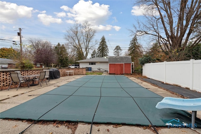 view of swimming pool featuring a water slide and a patio