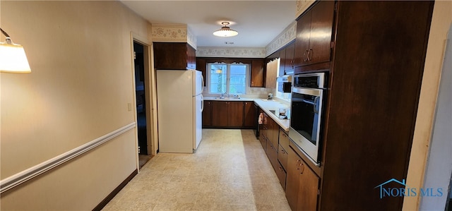 kitchen featuring dark brown cabinetry, stainless steel oven, white fridge, and black electric stovetop