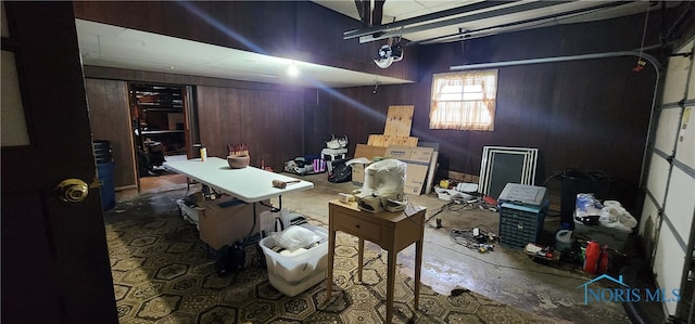 garage with a garage door opener and wooden walls