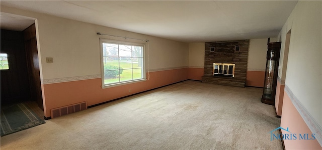 unfurnished living room featuring light colored carpet and a brick fireplace