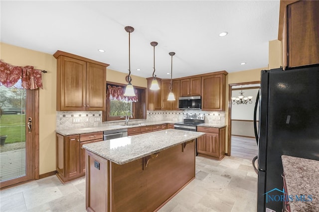 kitchen featuring sink, hanging light fixtures, tasteful backsplash, a kitchen island, and appliances with stainless steel finishes