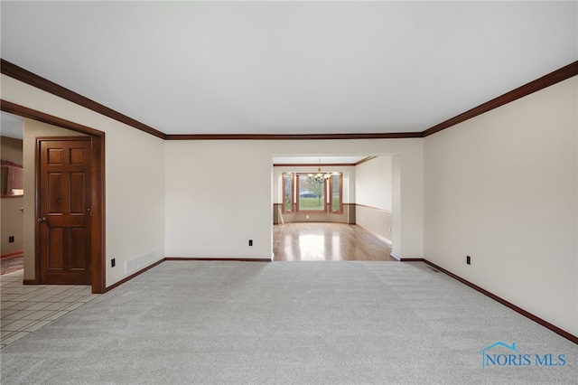 carpeted empty room with ornamental molding and a notable chandelier