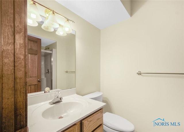 bathroom featuring vanity, toilet, and a shower with door