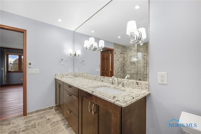 bathroom with hardwood / wood-style flooring, vanity, walk in shower, and a notable chandelier