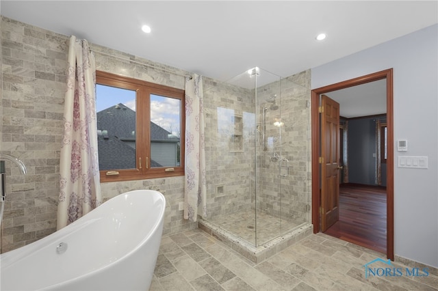 bathroom with plus walk in shower and hardwood / wood-style flooring