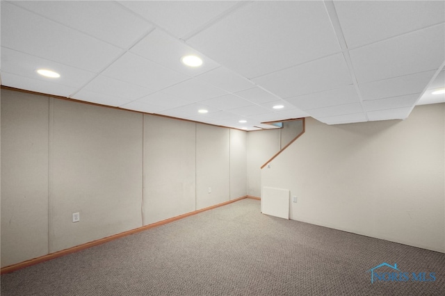 basement with carpet flooring and a paneled ceiling