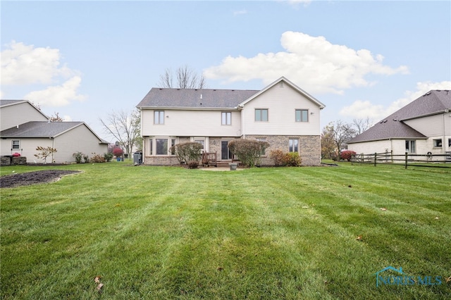 rear view of house featuring a lawn