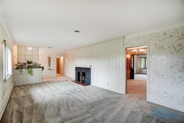 unfurnished living room featuring light colored carpet and a baseboard radiator