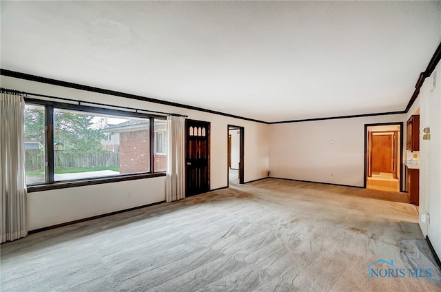 carpeted spare room with crown molding