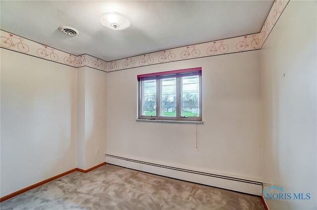 carpeted empty room featuring a baseboard heating unit