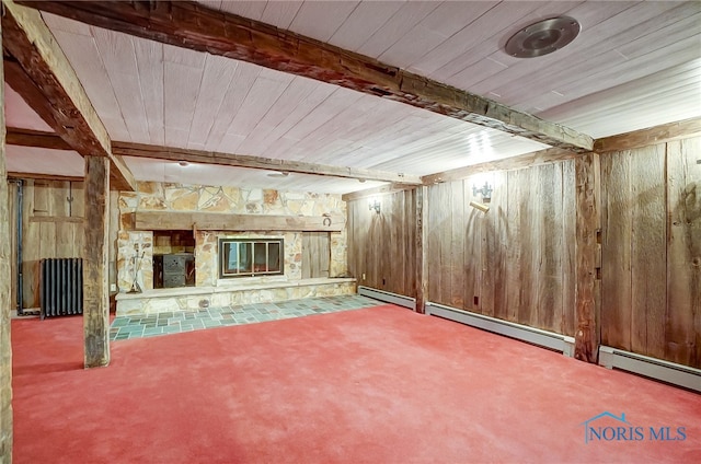 basement with wooden walls, carpet flooring, a fireplace, a baseboard radiator, and wood ceiling