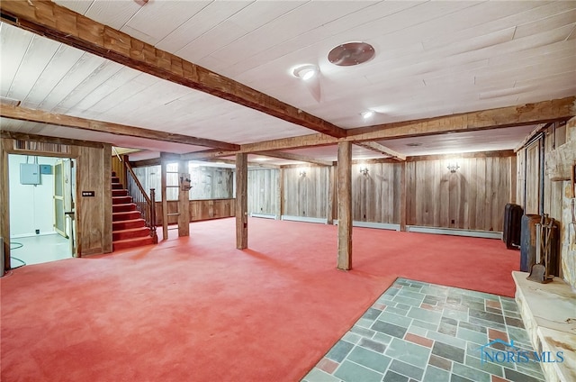 basement featuring carpet floors, a baseboard heating unit, and wood walls