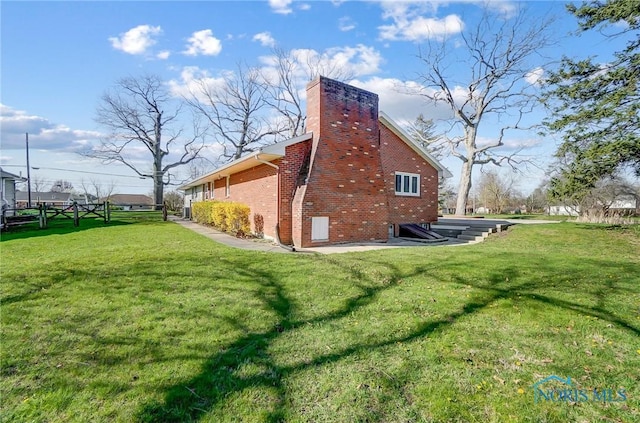 1362 Conneaut Ave, Bowling Green, OH 43402 - view of side of home featuring brick siding, a lawn, and a chimney