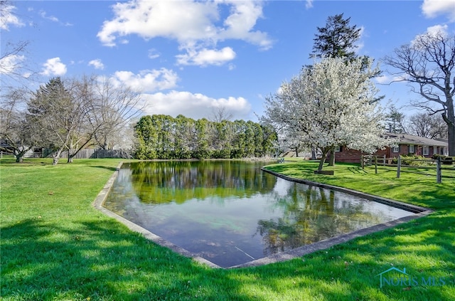 view of property's community with a lawn and a water view