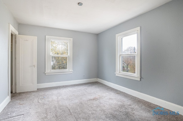 unfurnished room featuring light colored carpet