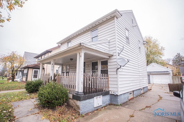 view of front of house featuring a porch, a garage, and an outbuilding