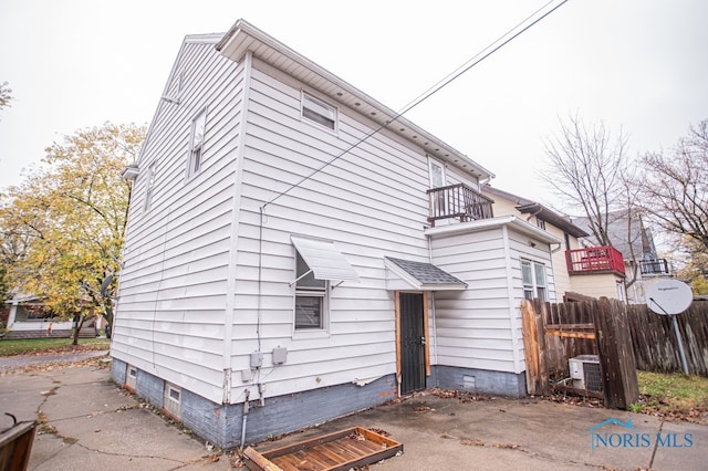 rear view of property with central AC unit and a balcony