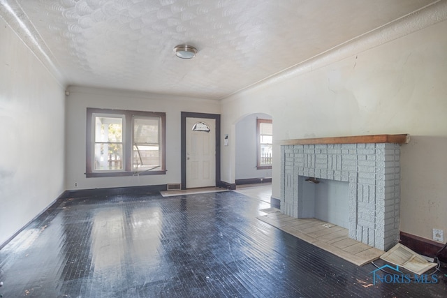 unfurnished living room featuring a textured ceiling, dark hardwood / wood-style flooring, and a fireplace