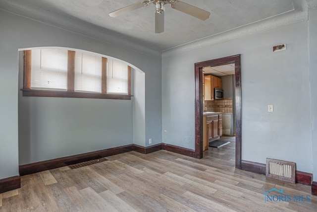 unfurnished room featuring ceiling fan, light hardwood / wood-style floors, and a textured ceiling