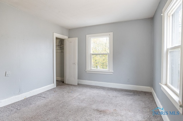 unfurnished bedroom with light carpet and a closet