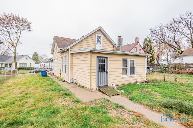 rear view of property with a yard