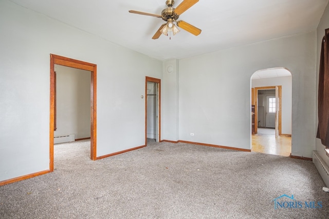 carpeted spare room with ceiling fan and a baseboard heating unit